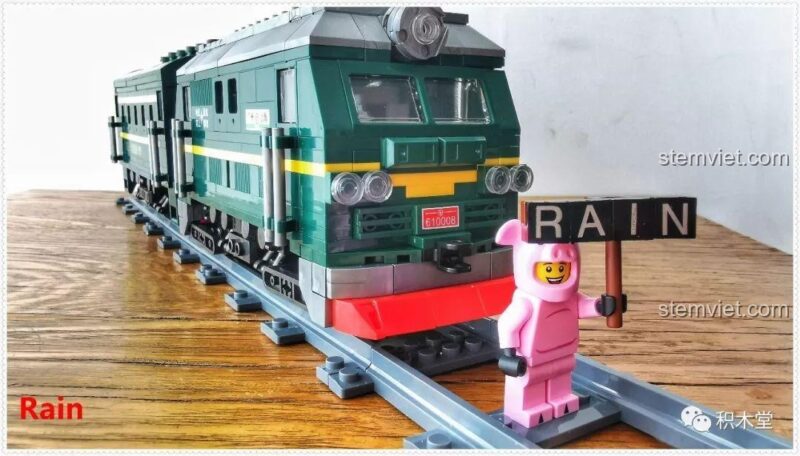 Đoàn tàu hỏa xanh lá cây Panlos Brick 610008 và minifigure trên đường ray, thể hiện sự sống động của cảnh quan.
