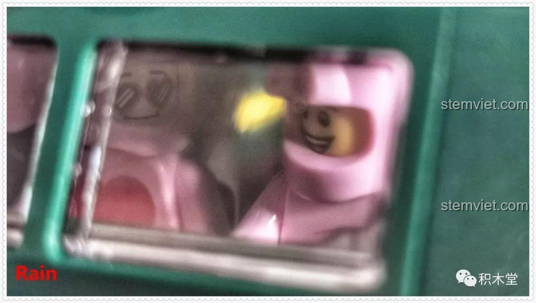 Hai nhân vật minifigure đang ngồi trong buồng lái của tàu hỏa, thể hiện khả năng tương tác của bộ lắp ráp Tàu Hỏa Xanh Lá Cây Panlos Brick 610008.