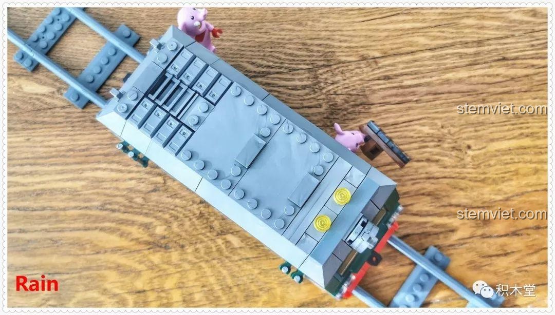 Cận cảnh phần dưới của đầu tàu bộ lắp ráp Tàu Hỏa Xanh Lá Cây Panlos Brick 610008, cho thấy cấu trúc bánh xe và khung gầm chi tiết.