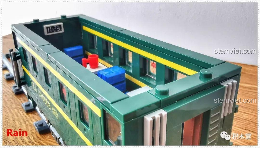 Toa khách của bộ lắp ráp Tàu Hỏa Xanh Lá Cây Panlos Brick 610008 nhìn từ bên hông, với chú heo Rain đang 'tạo dáng' bên cạnh.