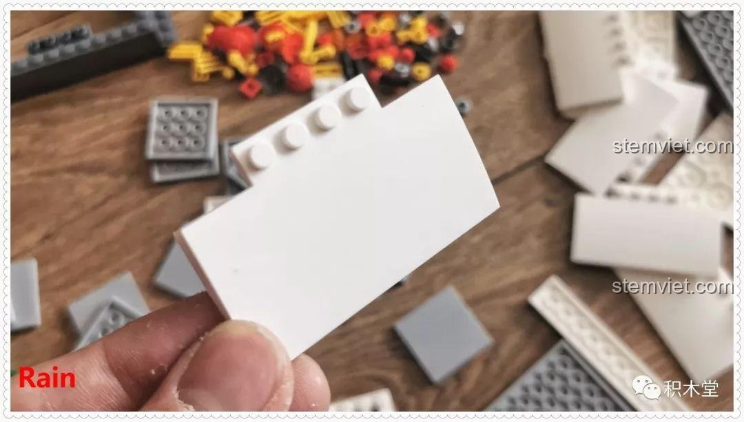 Sân ga của bộ lắp ráp Tàu Hỏa Xanh Lá Cây Panlos Brick 610008 đang được lắp ráp, với hai chú heo và voi minifigure đang đứng trên đó.