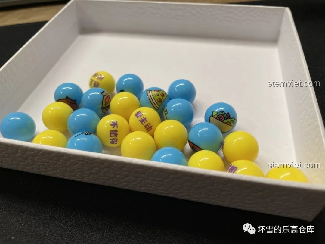 Các viên bi gashapon màu xanh và vàng với hình ảnh và chữ cái độc đáo của Pantasy 61007 Máy Vặn Trứng Xương Rồng.