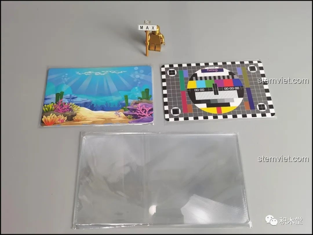 Hai tấm nền cảnh (biển và màn hình test) và một kính lúp phóng đại đi kèm bộ Pantasy 61008.