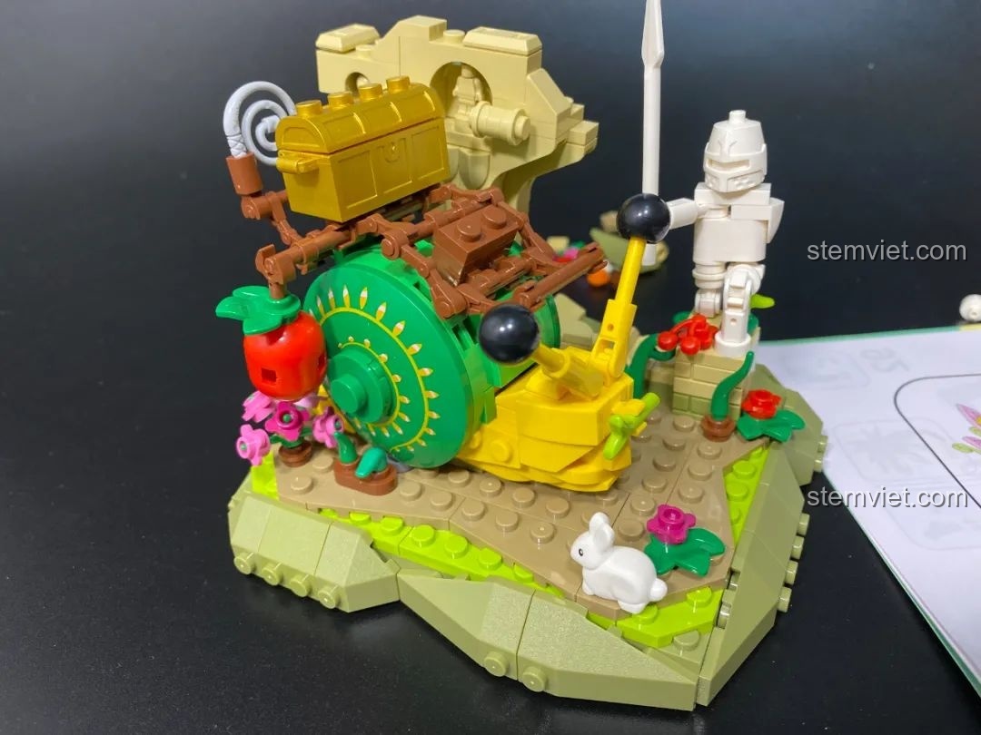 Các mảnh ghép trong suốt màu hồng và tím của túi số 4 và cuốn hướng dẫn lắp ráp Pantasy 15003, chuẩn bị cho việc xây dựng bông hoa và lồng.