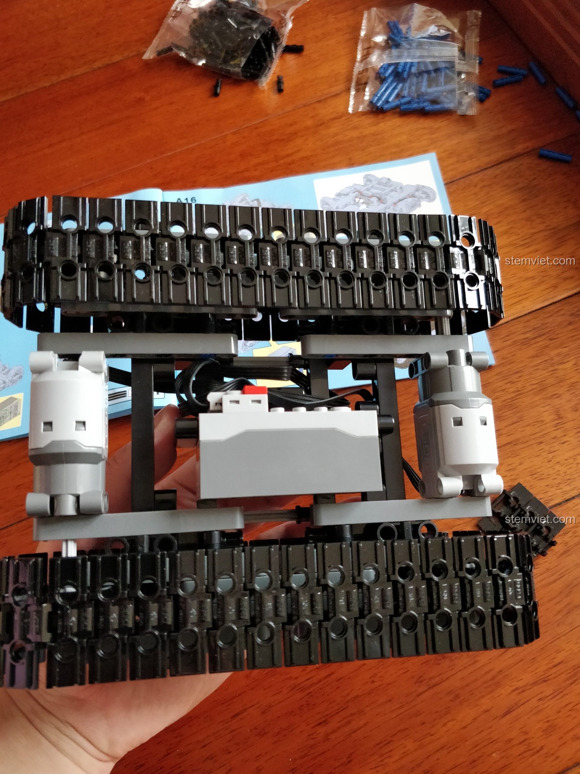 Phần gầm xe hoàn chỉnh của bộ lắp ráp Máy xúc kỹ thuật Technic CaDA giá bình dân, sẵn sàng cho các bước tiếp theo.