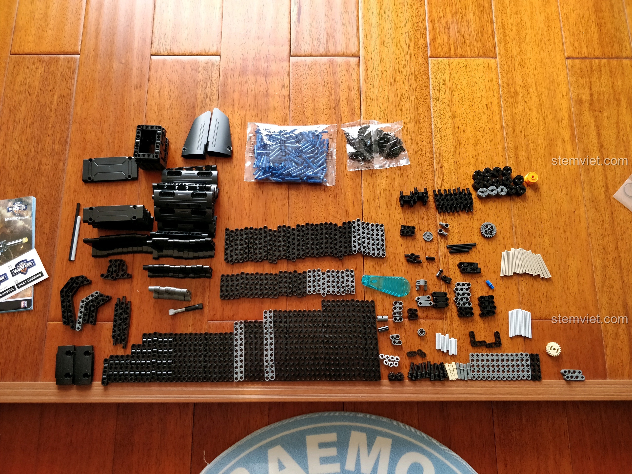 Các chi tiết của bộ xếp hình Mô súng trường chiến đấu 81005 được phân loại và sắp xếp trên sàn gỗ chuẩn bị lắp ráp.