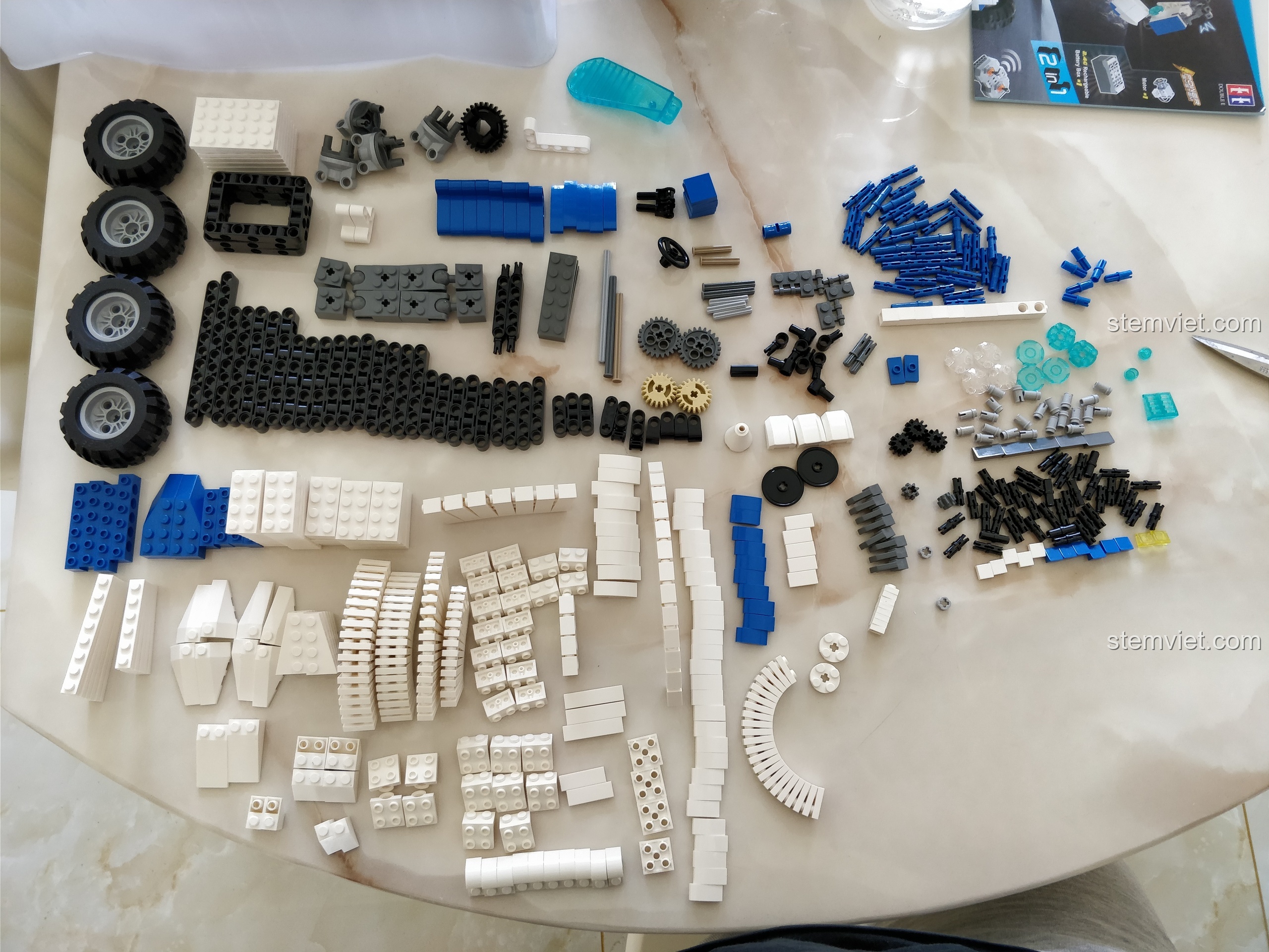 606 chi tiết của bộ lắp ráp CaDA C51028 được phân loại theo màu sắc và hình dạng trên bàn.