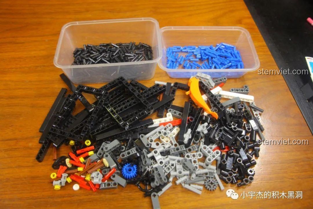 Các chi tiết nhựa màu đen và xanh được đổ ra khay để chuẩn bị cho quá trình lắp ráp bộ KBOX 10214.