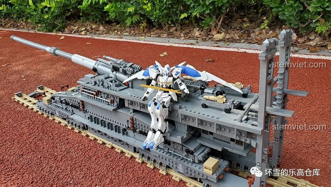 Mô hình Pháo Xe Lửa Dora 800mm Đức KAZI KY10005 được trưng bày cùng một mô hình Gundam, tạo nên cảnh tượng ấn tượng.