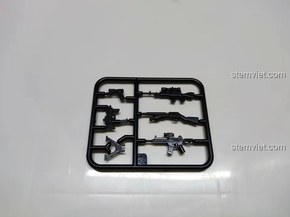 Vỉ vũ khí đi kèm cho các minifigure trong bộ lắp ráp WOMA C0898, gồm nhiều loại súng khác nhau.