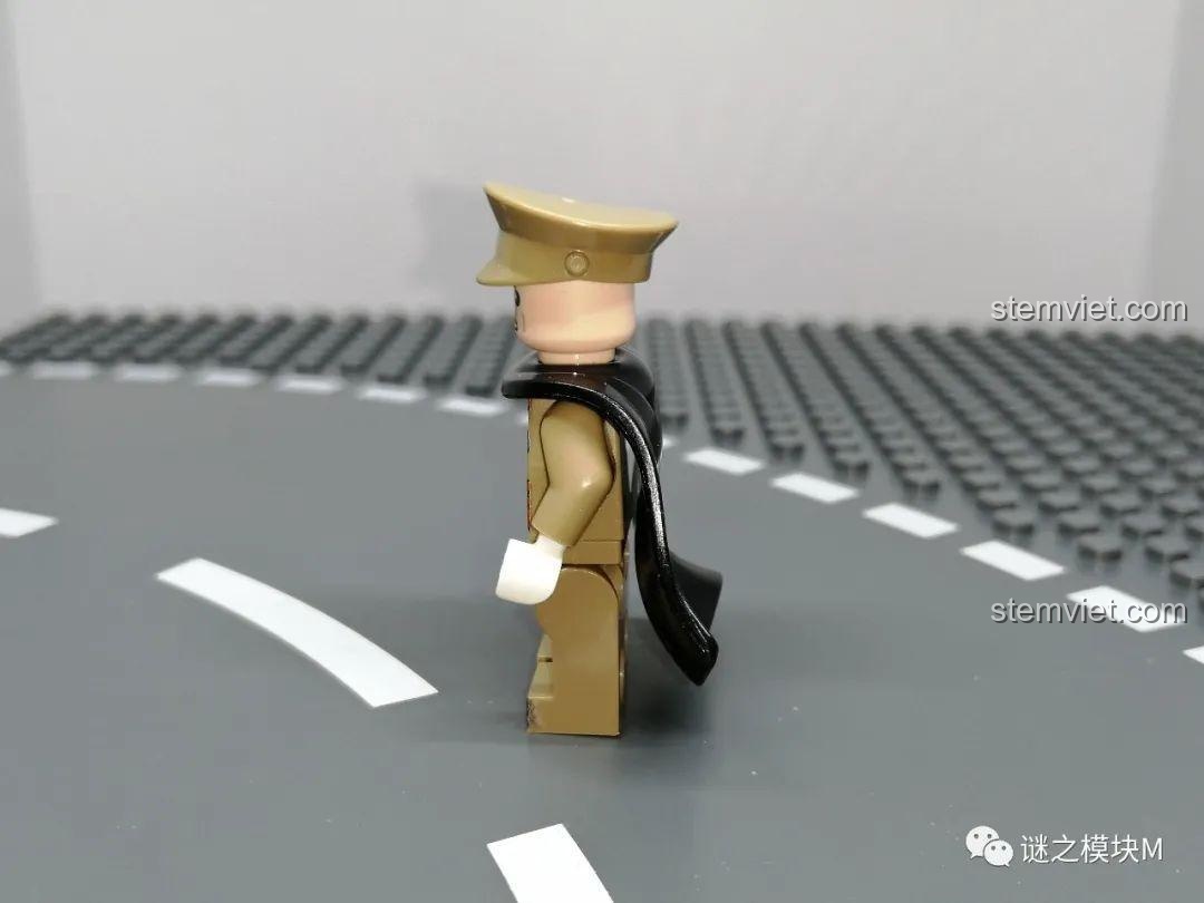 Góc nghiêng của minifigure quân đội phụ lục với áo choàng đen, thể hiện sự vừa vặn của áo choàng. Đồ chơi lắp ráp sáng tạo.