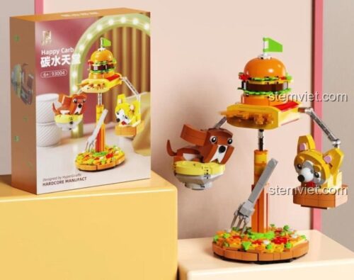 Hộp sản phẩm bộ đồ chơi Happy Carb 93004 của hãng 启智乐, mô tả hai chú chó Corgi và chó nâu đang chơi đùa quanh chiếc bánh burger khổng lồ, phù hợp cho bé 6+ tuổi