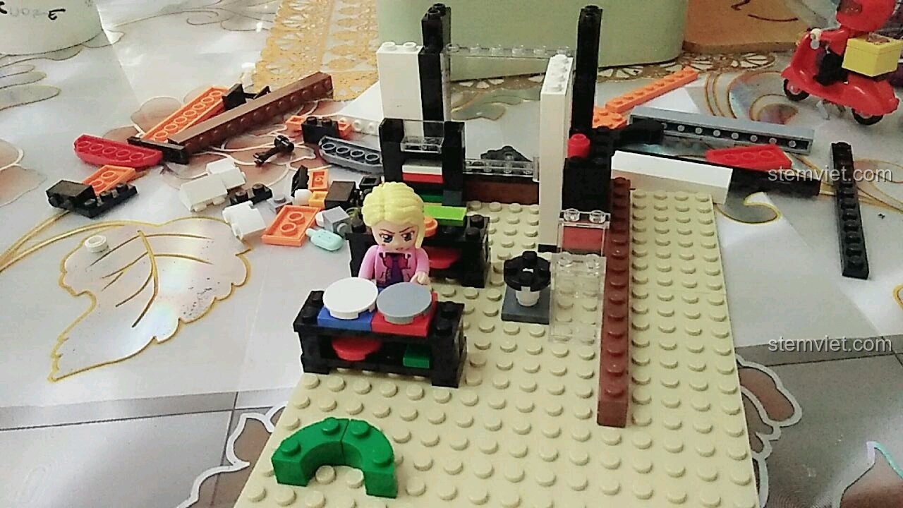 Minifigure cô chủ Tử Kỳ đang lắp ráp khung và nội thất cơ bản bên trong mô hình QMAN 1133 Cửa Hàng Tiện Lợi.