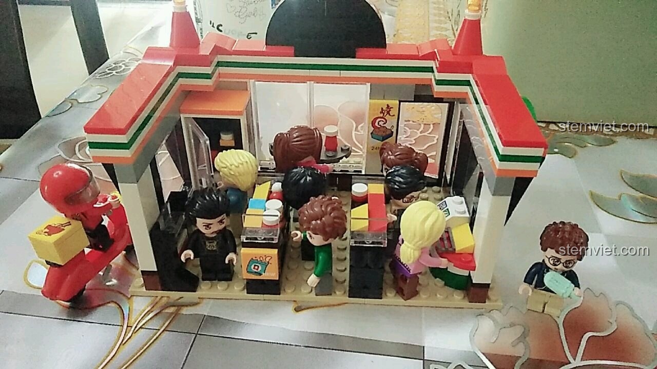 Ảnh hộp sản phẩm và mô hình hoàn thiện của bộ lắp ghép Cửa Hàng Tiện Lợi QMAN 1133, có ghi rõ số hiệu, số chi tiết 319 và kích thước hộp.