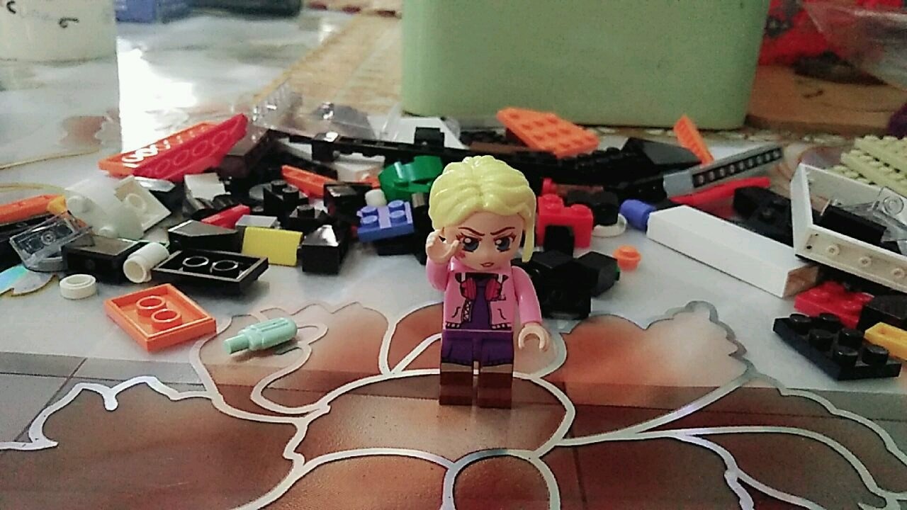 Ảnh chụp cận cảnh quá trình lắp ráp bộ đồ chơi QMAN 1133, minifigure đang sắp xếp hàng hóa lên kệ.