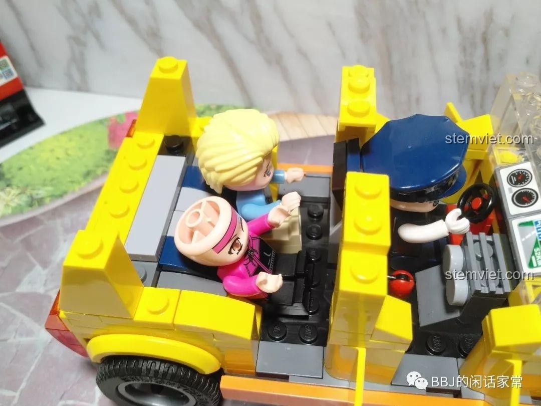 Hai minifigure hành khách ngồi ở hàng ghế sau của xe taxi, không gian khá chật hẹp.