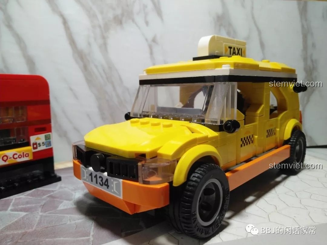Mô hình xe taxi QMAN 1134 đã hoàn thiện, góc nhìn từ phía trước bên cạnh máy bán nước tự động.