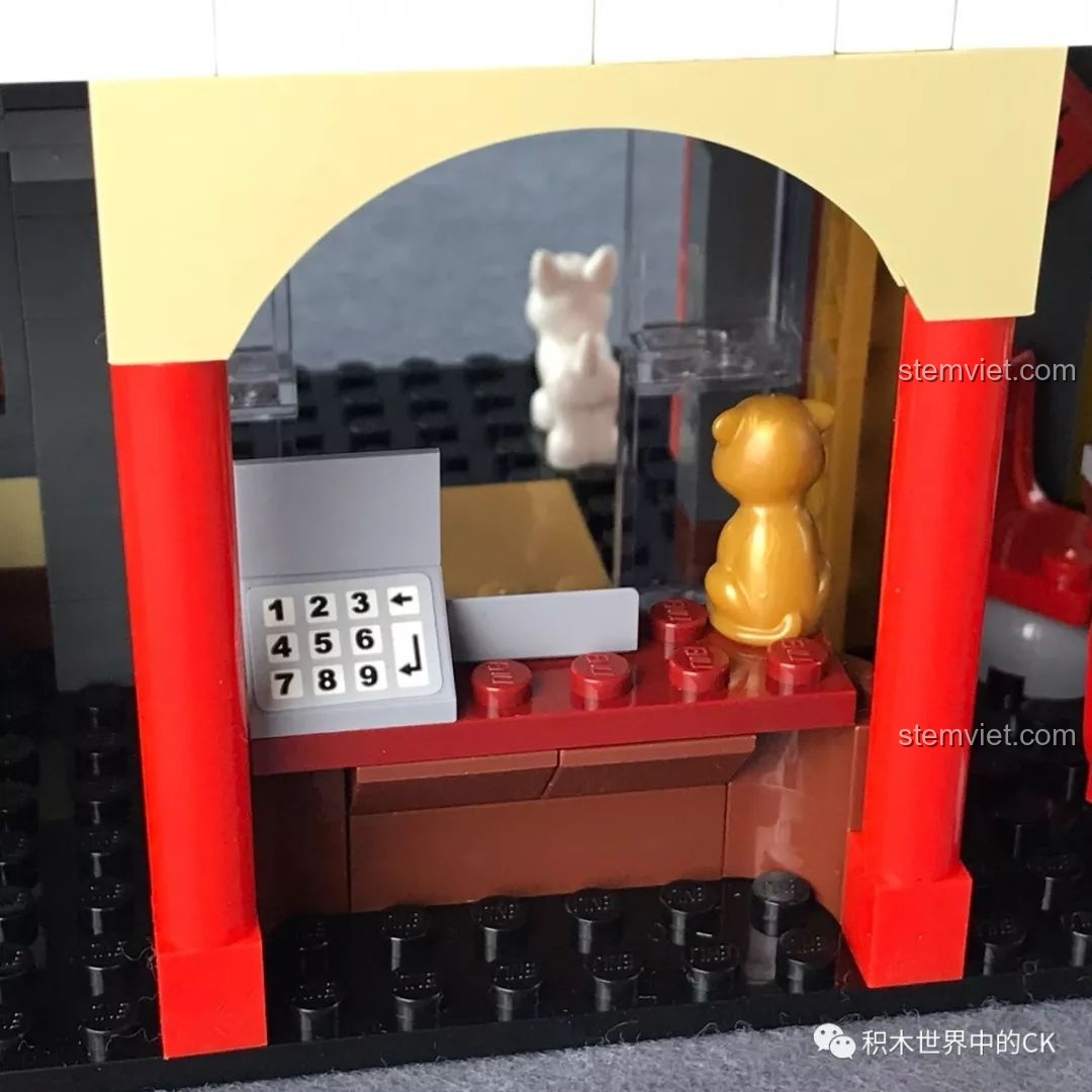 Cận cảnh quầy thu ngân của nhà hàng QMAN 1137 với máy tính tiền và chú mèo thần tài, thể hiện sự chi tiết.