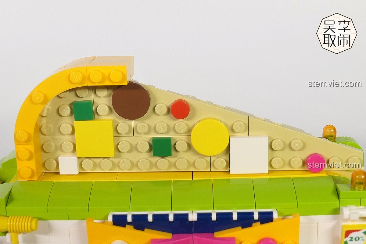 Miếng pizza khổng lồ được lắp ráp từ các mảnh ghép trên nóc xe của bộ đồ chơi mô hình Xe bán pizza lưu động QMAN.