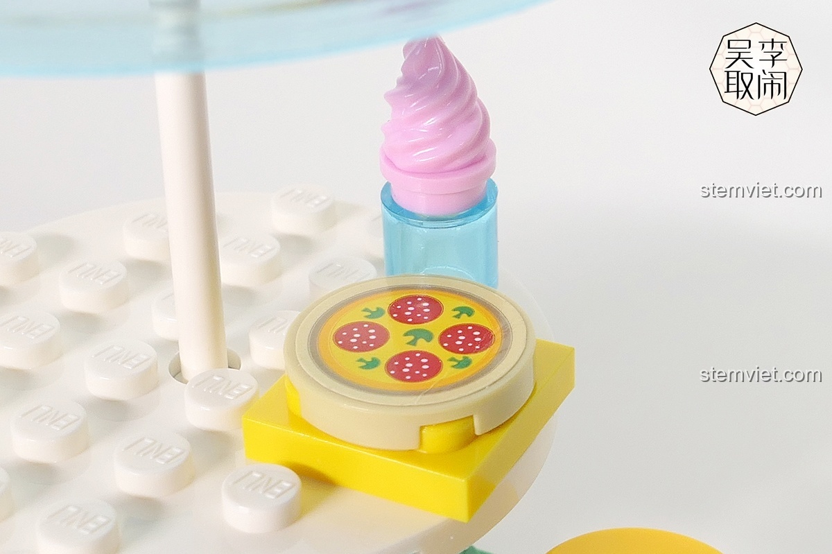 Cận cảnh chi tiết bánh pizza và ly kem trong bộ đồ chơi xếp hình Xe Tải Pizza Vui Vẻ QMAN, cho thấy chất lượng in ấn tốt.