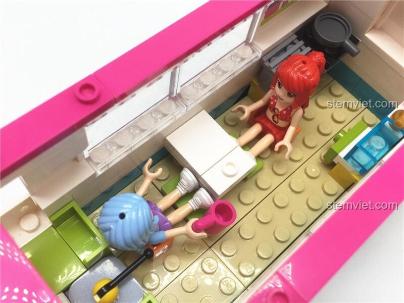 Hai minifigures đang ngồi chơi bên trong xe, cho thấy không gian rộng rãi và nhiều tiềm năng kể chuyện của bộ đồ chơi.