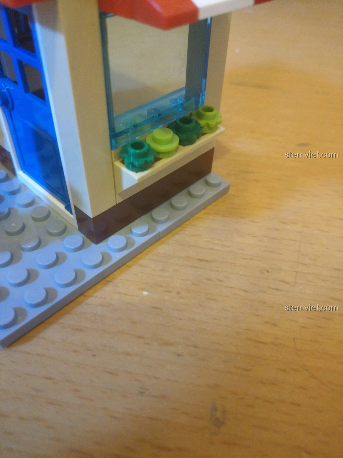 Chi tiết cây xanh mới đúc bên cửa sổ của mô hình nhà sách trong bộ QMAN 2804, tăng tính thẩm mỹ.