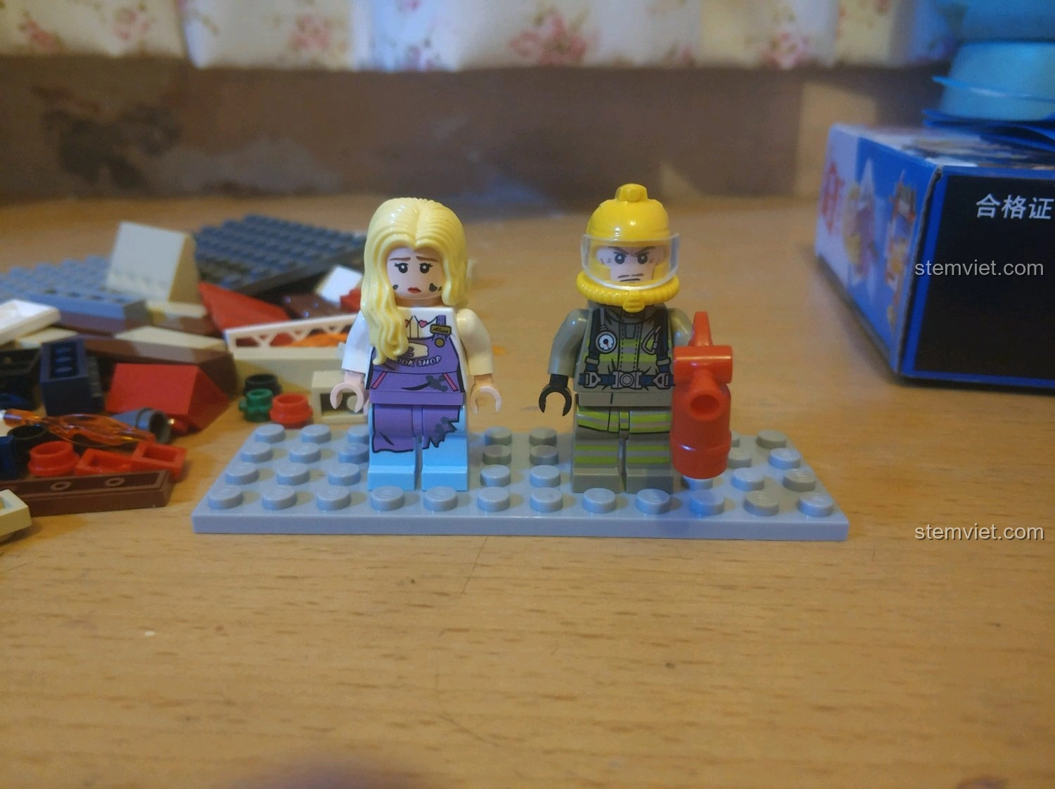 Hai minifigures độc đáo của bộ QMAN 2804 Cứu Hỏa Nhà Sách: lính cứu hỏa với bình chữa cháy và nhân viên nhà sách.