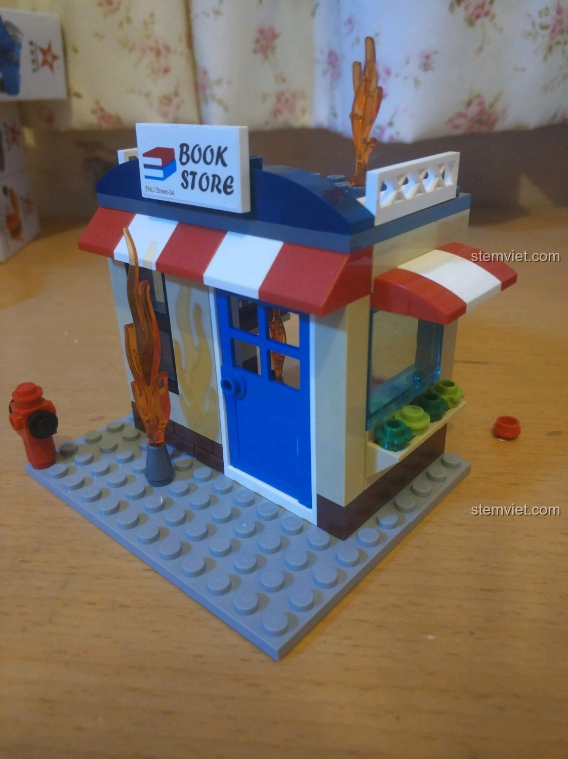 Góc nghiêng của mô hình nhà sách đang cháy QMAN 2804, thể hiện rõ mái hiên và cửa ra vào.