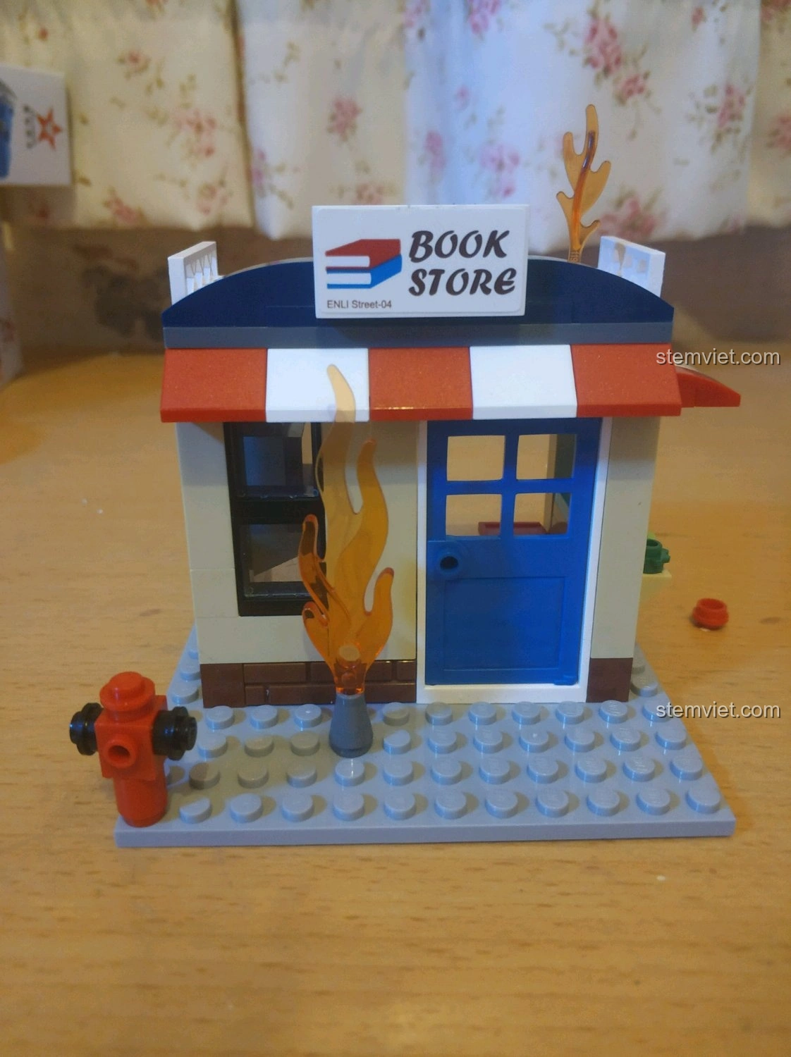 Mô hình nhà sách đang cháy đã hoàn thành từ bộ lắp ráp QMAN 2804, với vòi cứu hỏa và ngọn lửa.