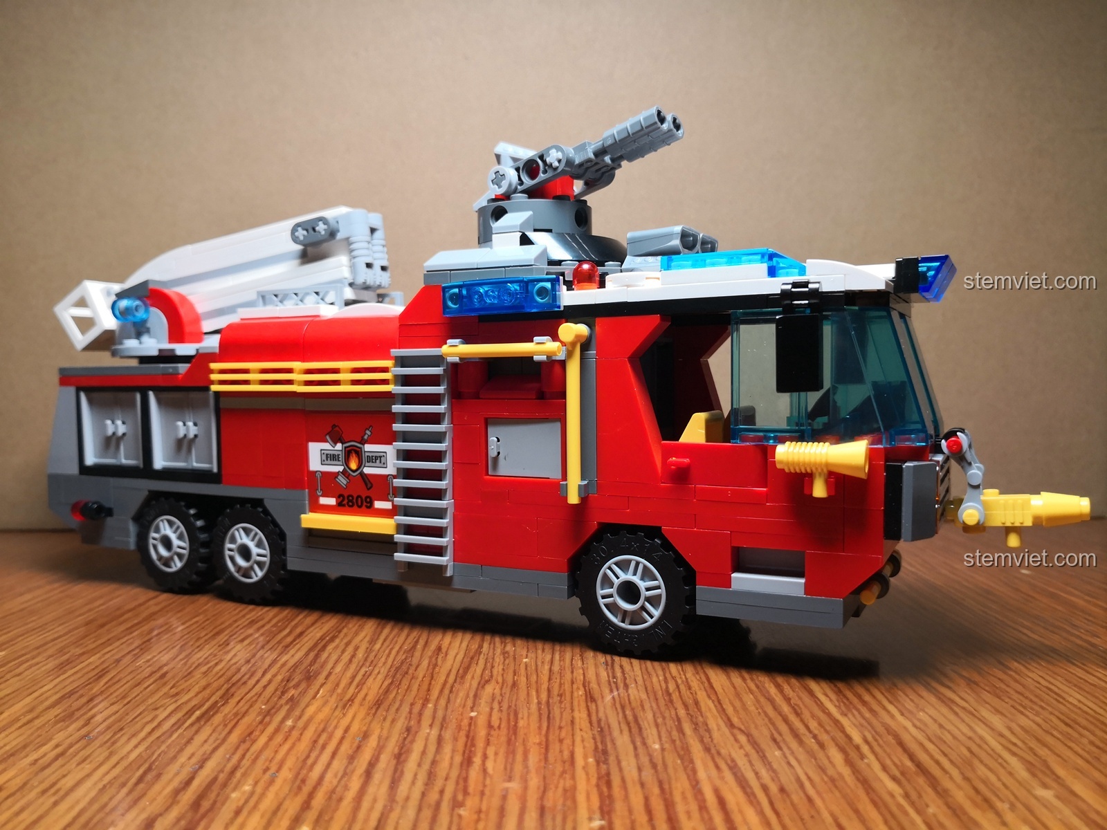 Mô hình xe cứu hỏa QMAN 2809 hoàn chỉnh, góc nhìn từ bên hông trái, màu sắc đỏ trắng nổi bật.
