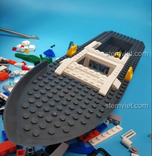 Lắp ráp phần mũi của tàu cảnh sát Sluban B0657. Thân tàu nguyên khối màu xám được bao quanh bởi các mảnh ghép.