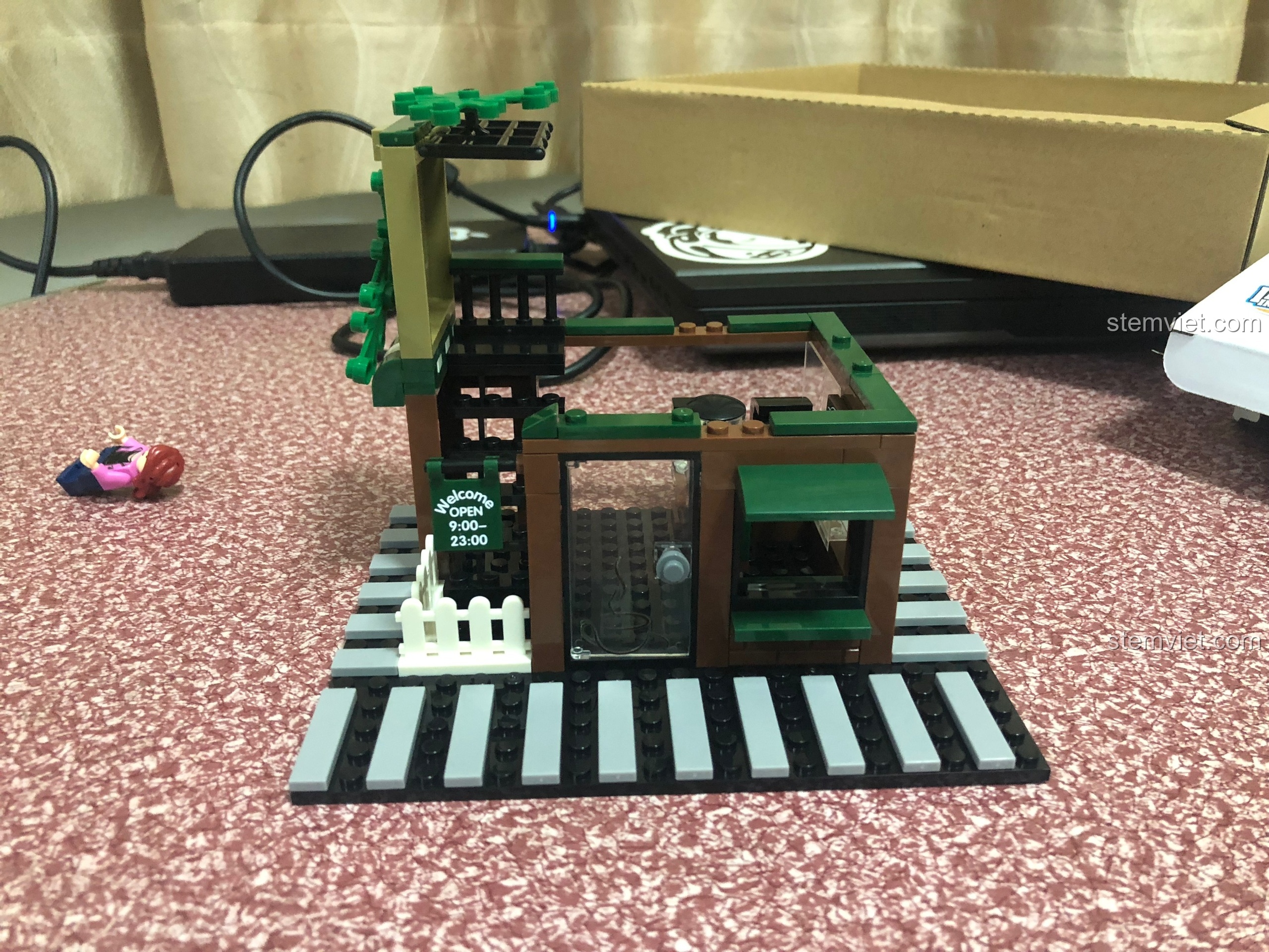 Mô hình tiệm cà phê Sembo 601019 đang trong quá trình lắp ráp tầng một với cửa ra vào và hàng rào.