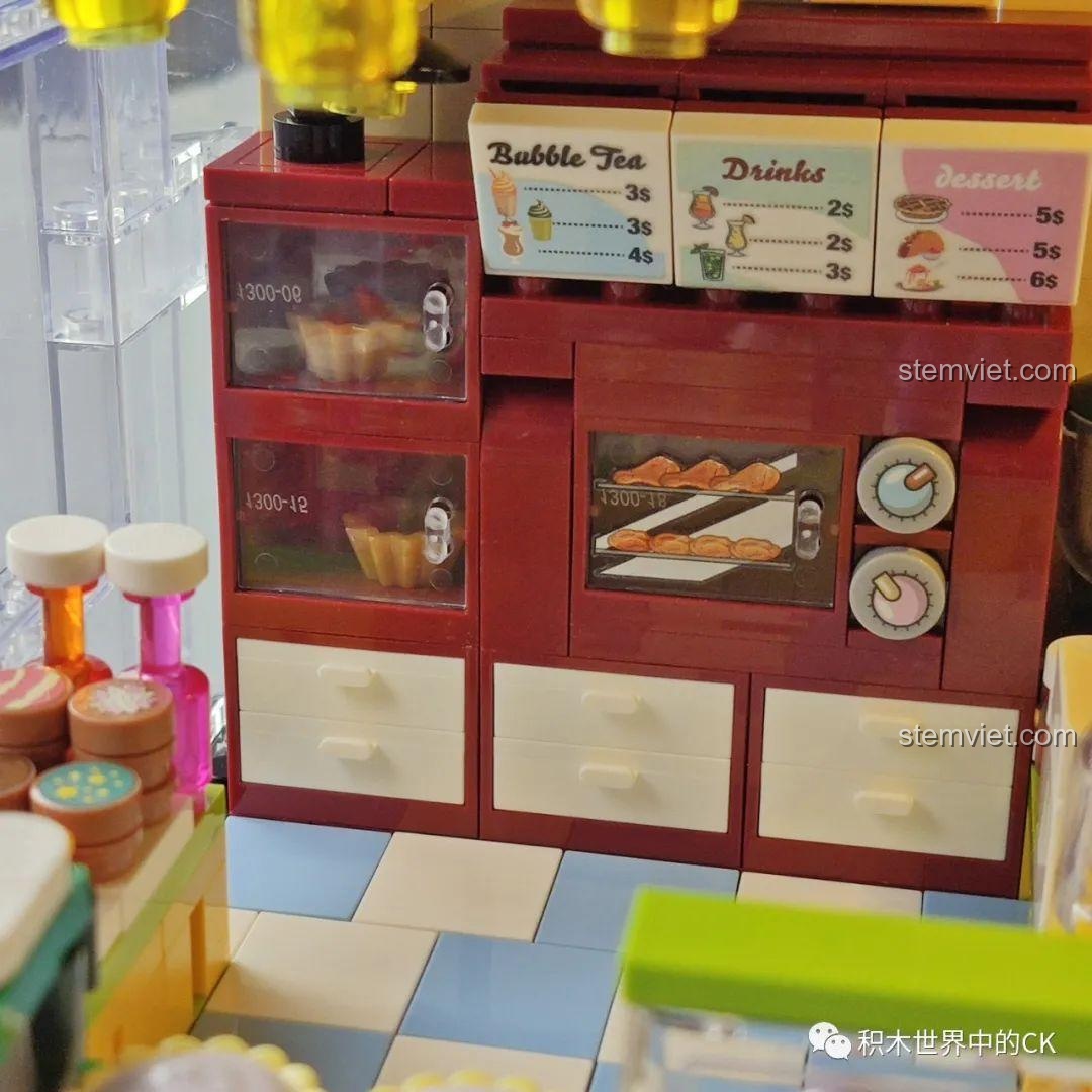 Cận cảnh quầy bánh ngọt và đồ ăn vặt trong mô hình Cửa hàng trà sữa JIAZHI SY 5209, với bánh hotdog và bánh tart.