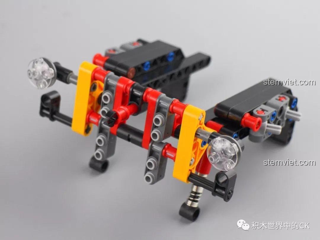 Cụm hệ thống treo trước của đồ chơi mô hình Rael LE-J901 với các giảm xóc màu vàng và khớp nối phức tạp.