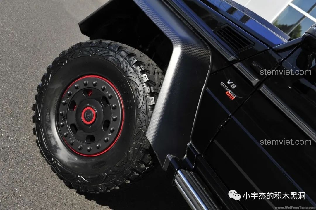 Ảnh xe Mercedes G63 AMG 6x6 thực tế màu đen, với 6 bánh xe và thiết kế hầm hố, đứng trước tòa nhà.