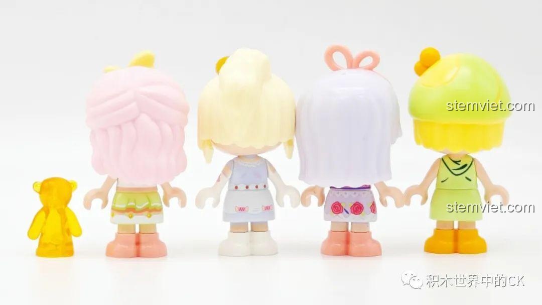 Mặt sau của bốn nhân vật công chúa mini từ bộ đồ chơi lắp ráp đèn bánh pudding Sembo Candy Planet, hiển thị chi tiết trang phục và kiểu tóc từ phía sau.