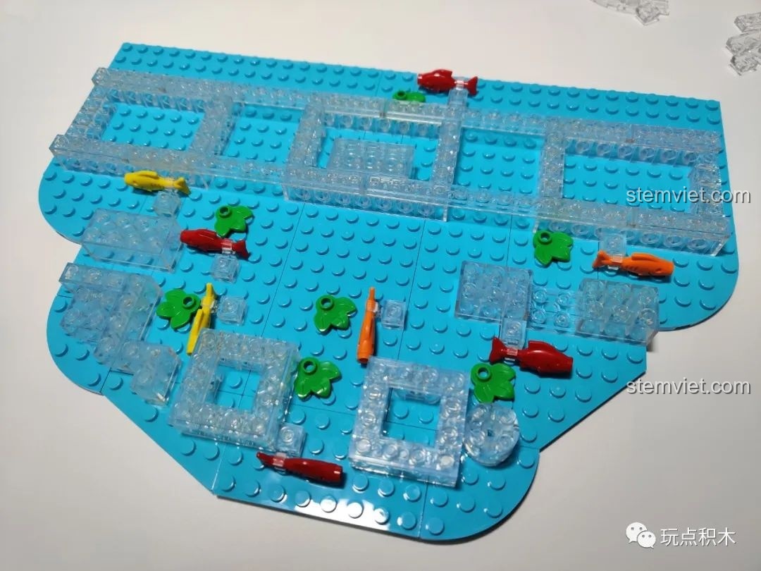 Đế nước của bộ lắp ghép Cá Chép Hóa Rồng Pantasy 18001 đang được lắp, với những chú cá nhỏ dưới đáy.