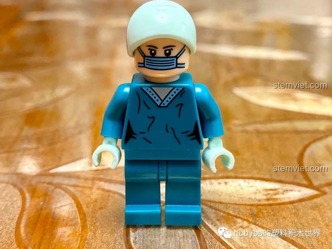 Minifigure bác sĩ phẫu thuật mặc đồ xanh, đội mũ, biểu cảm nghiêm túc.