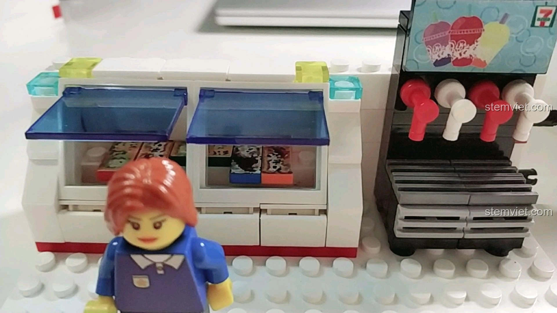 Máy pha chế đồ uống và quầy hàng trong mô hình cửa hàng tiện lợi 7-Eleven, với minifigure.