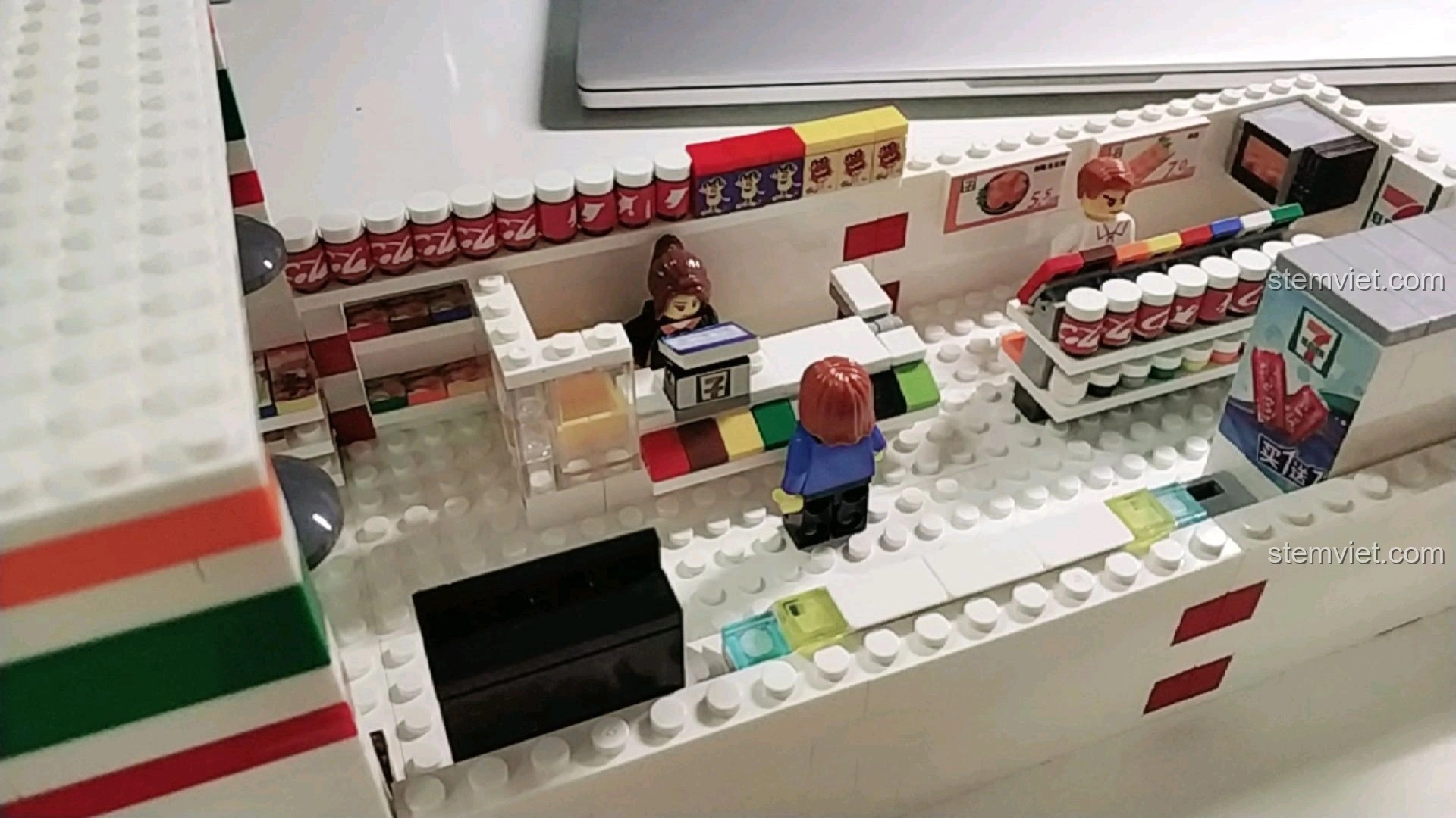 Góc nhìn rộng bên trong mô hình cửa hàng tiện lợi 7-Eleven đã lắp ráp, với các khu vực chức năng.