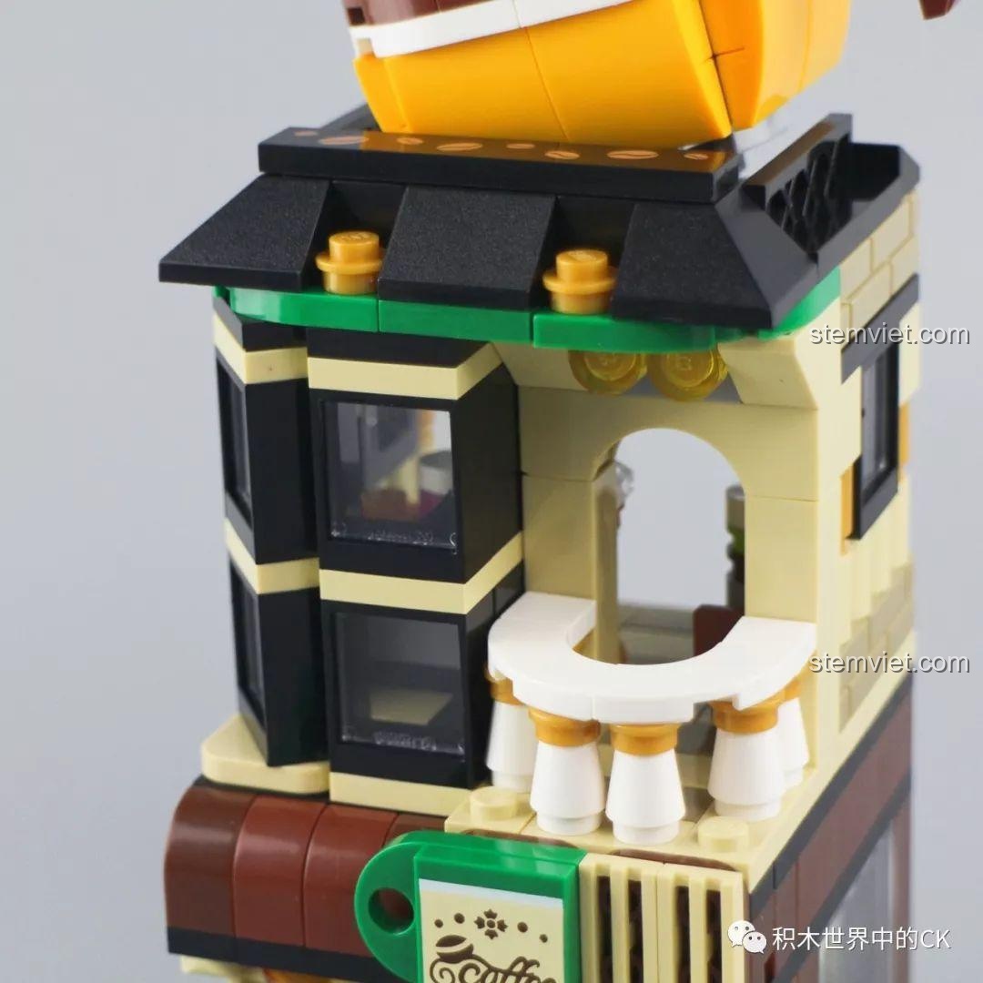 Cận cảnh chiếc cốc cà phê khổng lồ trên mái của mô hình đồ chơi lắp ráp Keepplay C0102 Crossroad Café, với chi tiết 'hơi nước' bốc lên.