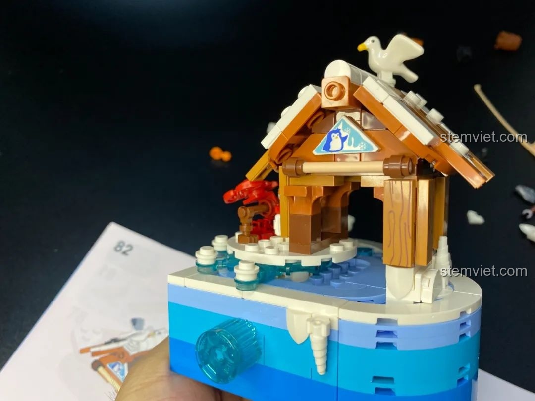 Ngôi nhà gỗ trong bộ lắp ráp Pantasy 61001 Snow BBQ gần hoàn thiện, với chi tiết chim hải âu trên mái nhà.