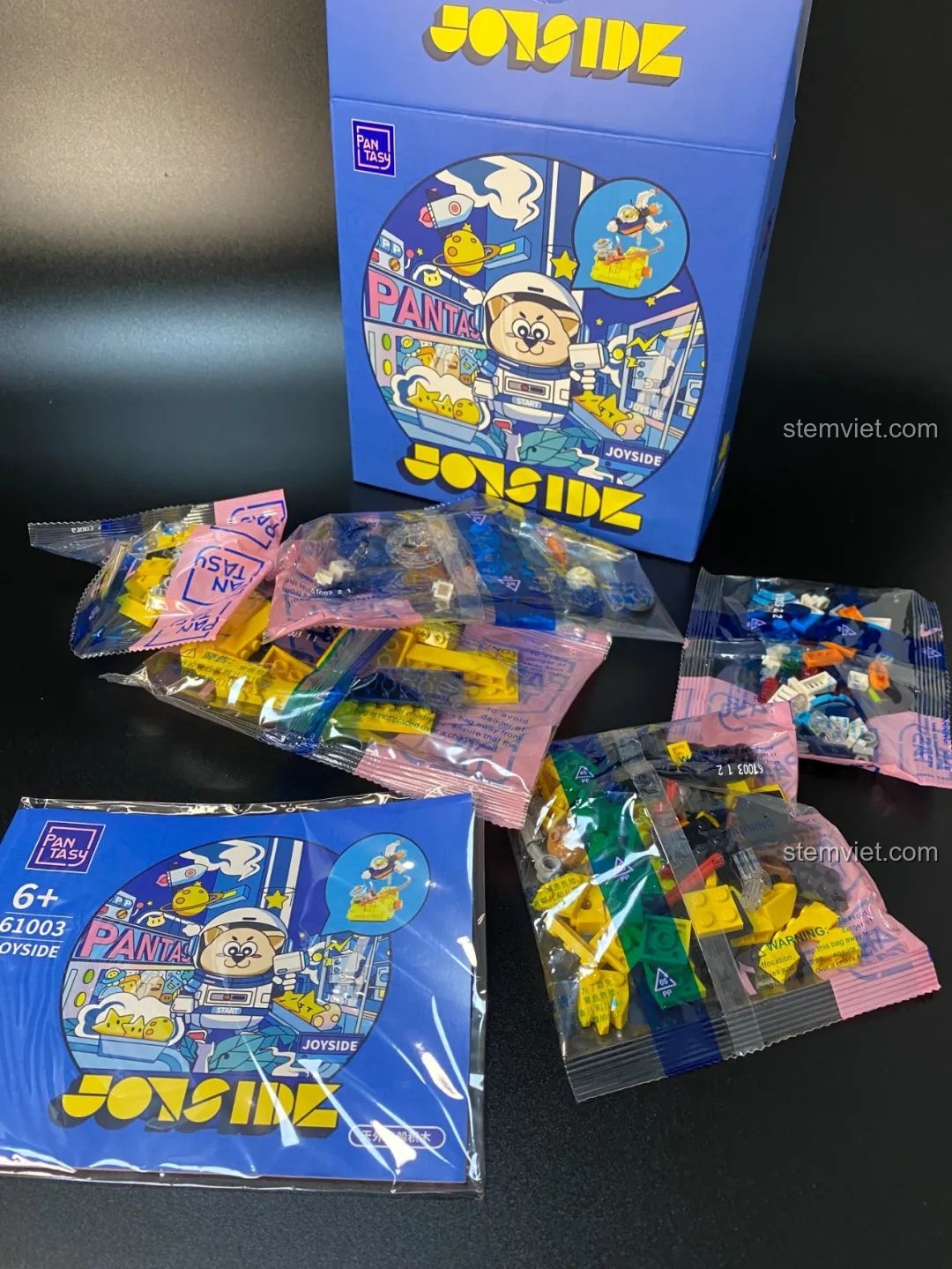 Bên trong hộp đồ chơi lắp ráp Pantasy 61003 Spaceship, bao gồm các túi mảnh ghép và sách hướng dẫn với bản đồ công viên Joyside ở khu vực không gian.