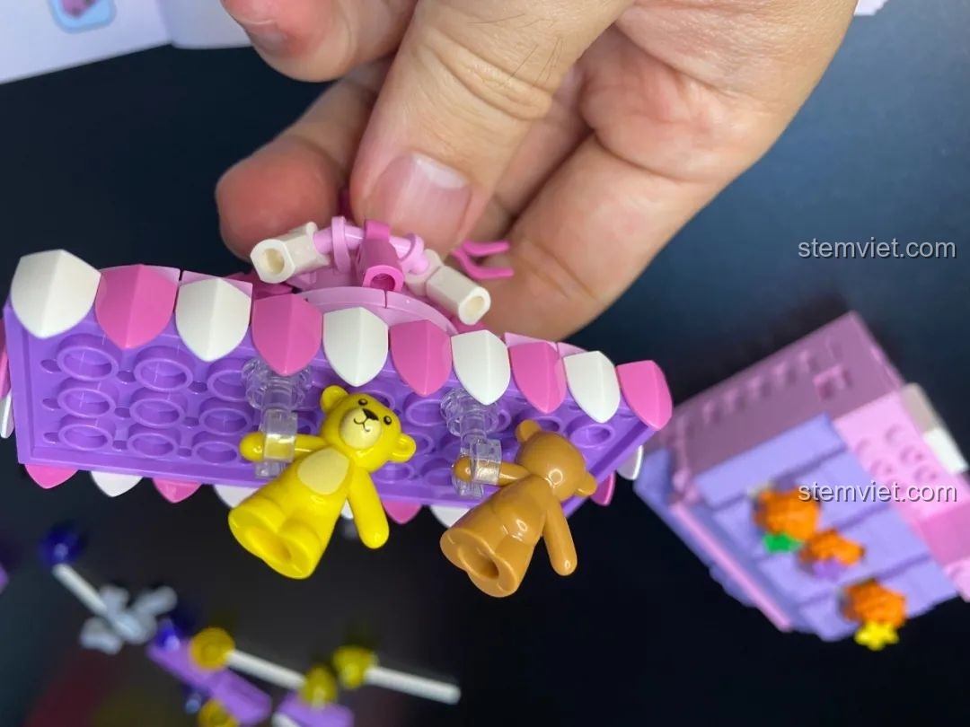 Hai chú gấu nhỏ được treo trên mái của quầy trò chơi trong bộ lắp ráp Pantasy 61004 Happy Hedgehog Whack-a-mole, tượng trưng cho phần thưởng.