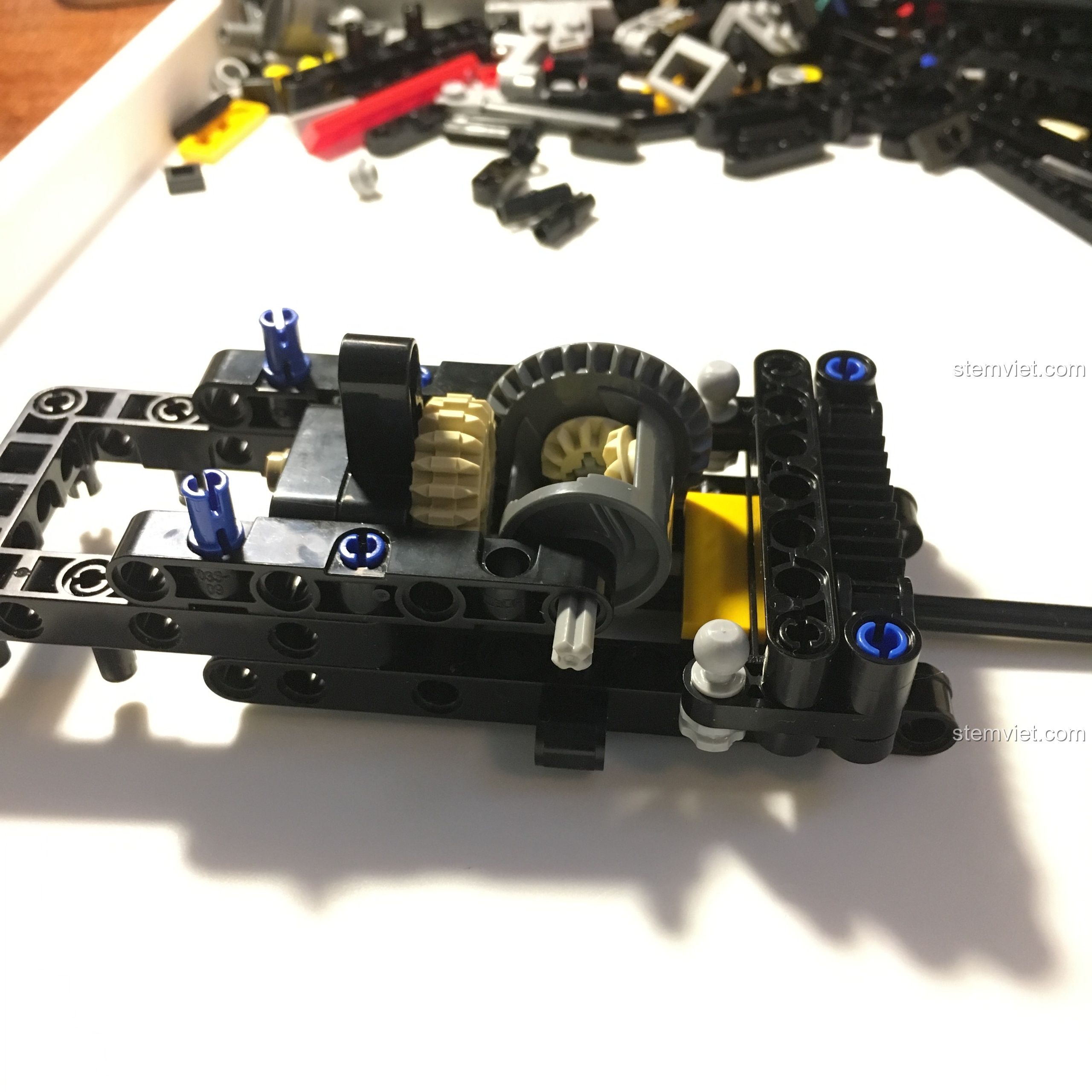 Cận cảnh hệ thống lái của xe Buggy địa hình CaDA, với các thanh nối và bánh răng nhỏ.