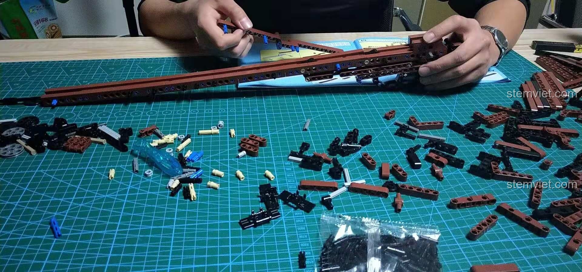 Quá trình lắp ráp bộ đồ chơi lắp ráp Mô hình súng bắn tỉa cho trẻ em 8+, bắt đầu với việc ghép các mảnh dài tạo thân súng.