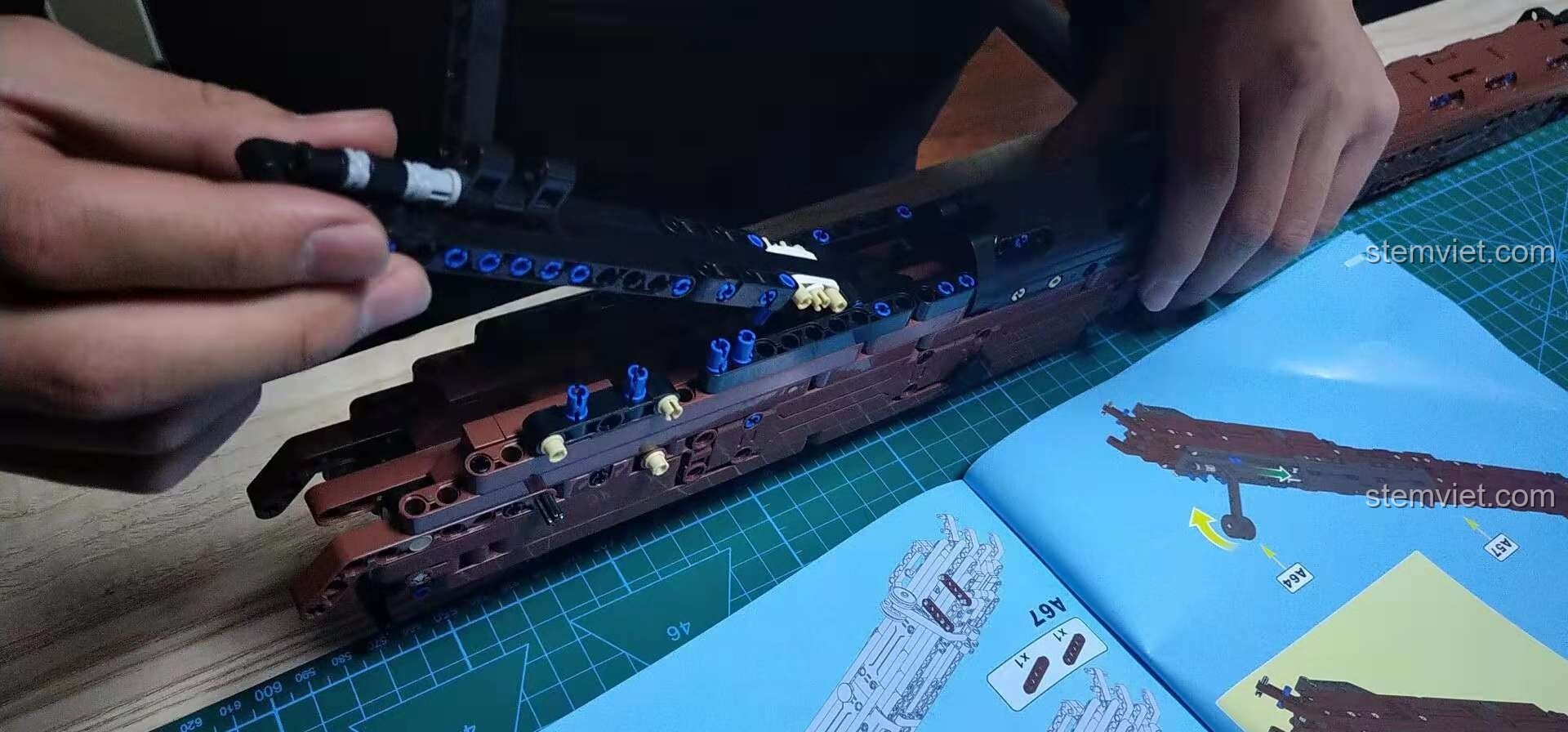 Cận cảnh một cụm chi tiết nhỏ trong quá trình lắp ráp đồ chơi mô hình súng bắn tỉa cho bé trai 8 tuổi, thể hiện độ phức tạp.