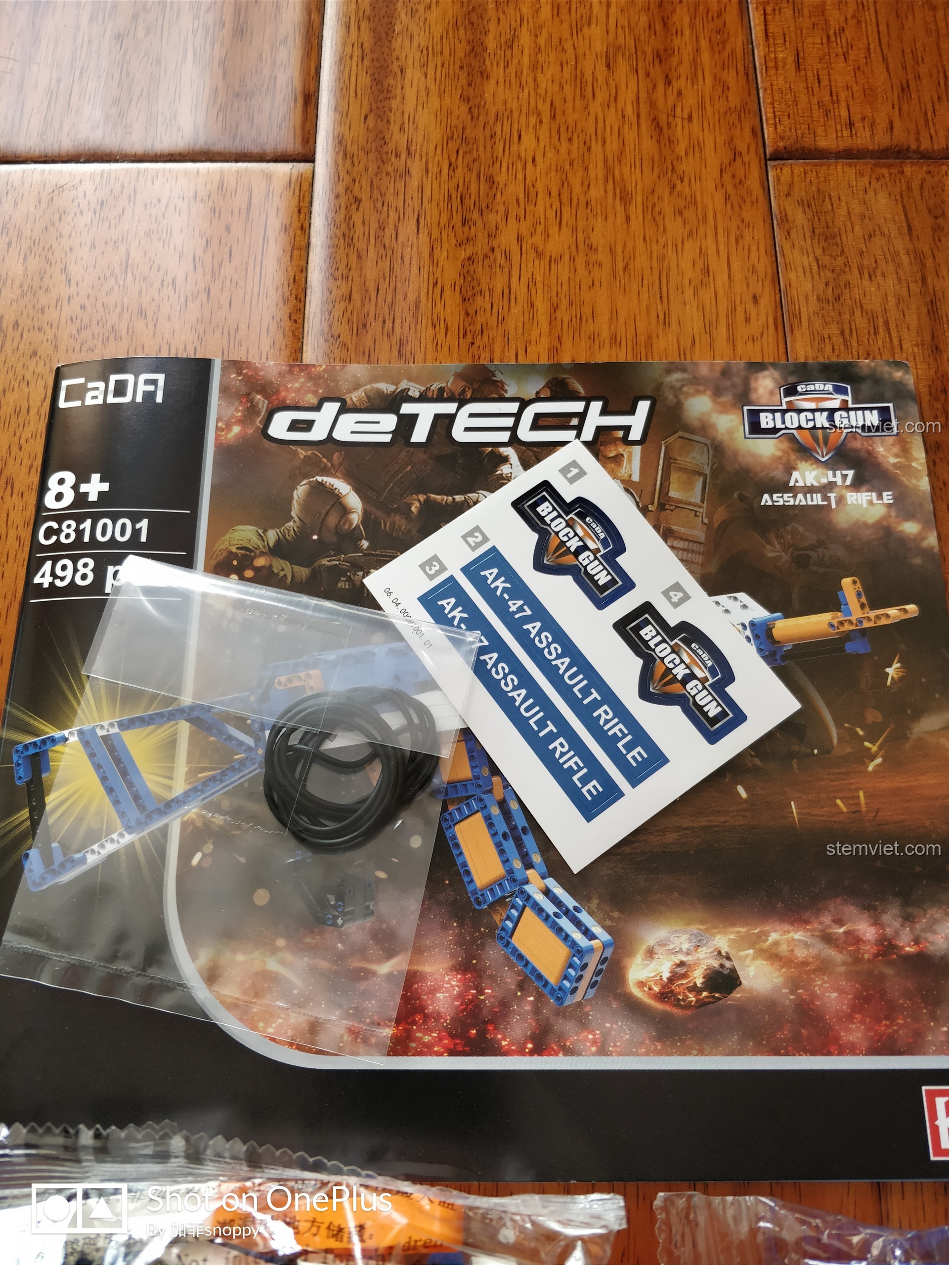 Các thành phần chính của bộ đồ chơi lắp ráp súng trường tấn công AK-47 CaDA C81001: túi linh kiện, sách hướng dẫn, sticker.