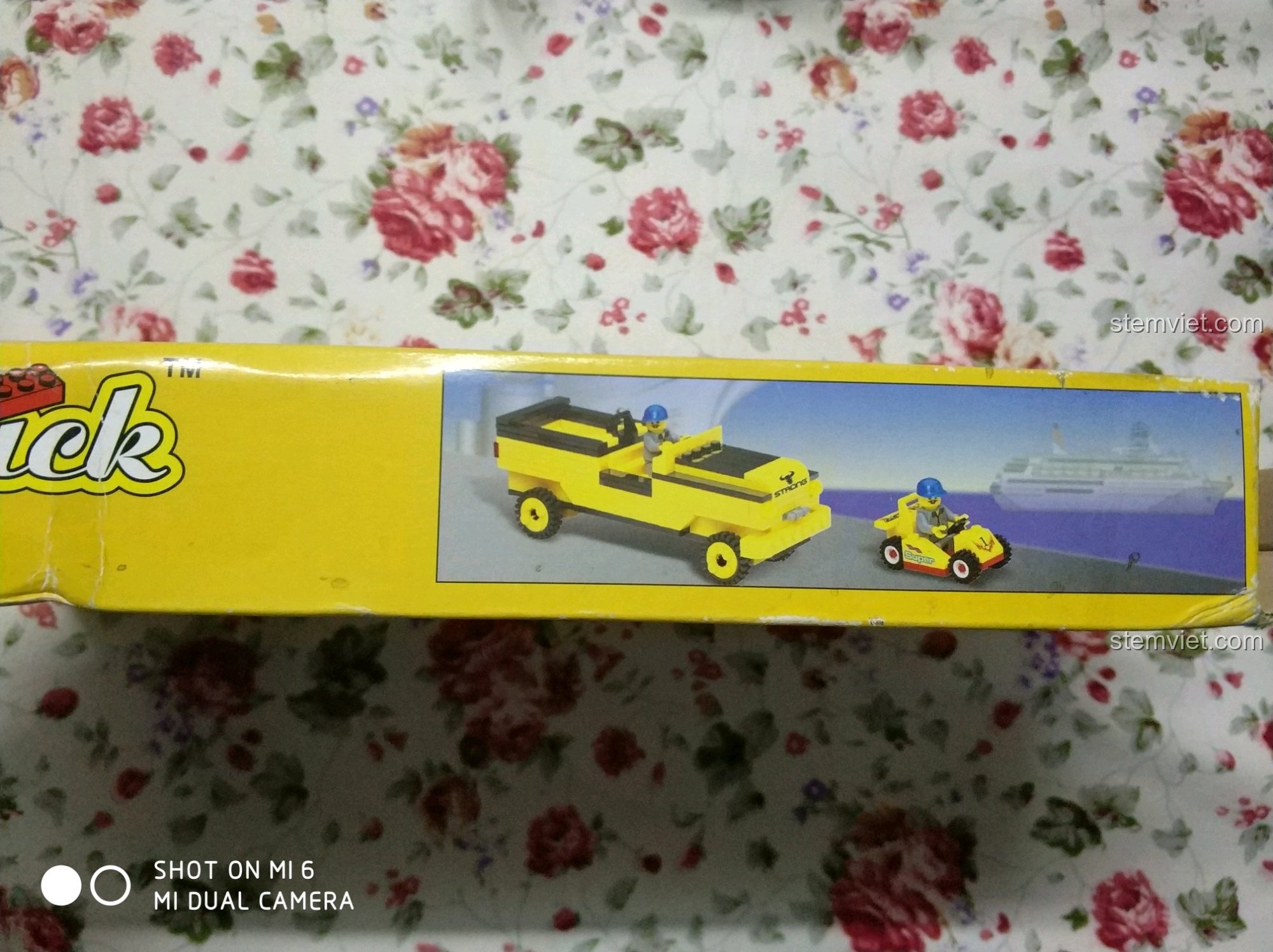 Cạnh hộp đồ chơi lắp ráp Enlighten 0493 Xe Nâng Hàng Lắp Ráp, với hình ảnh minh họa xe nâng và xe đua trên bến cảng.