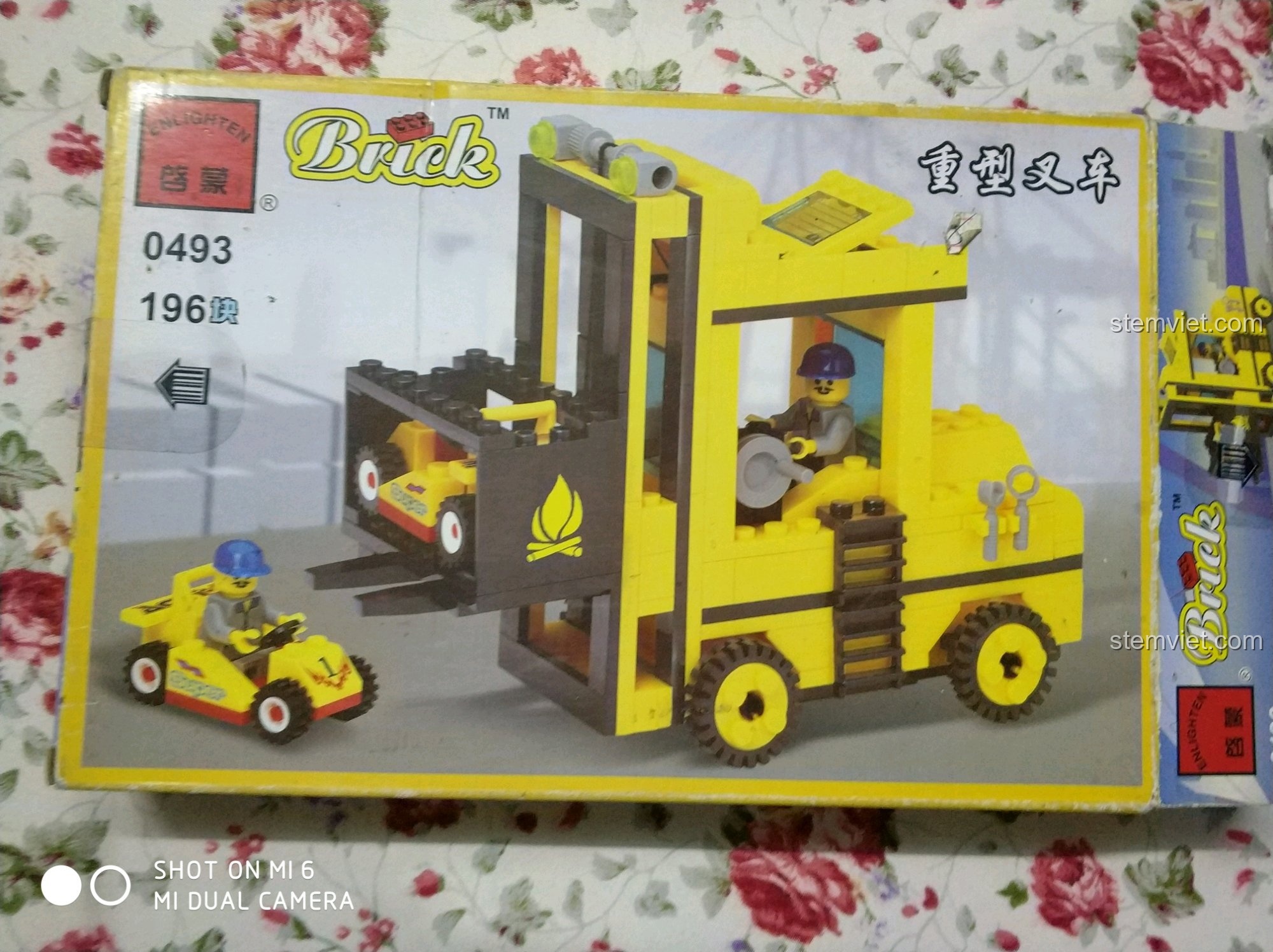 Hộp đồ chơi lắp ráp Enlighten 0493 Xe Nâng Hàng Hạng Nặng và Xe Đua Mini màu vàng nổi bật, thu hút mọi ánh nhìn.